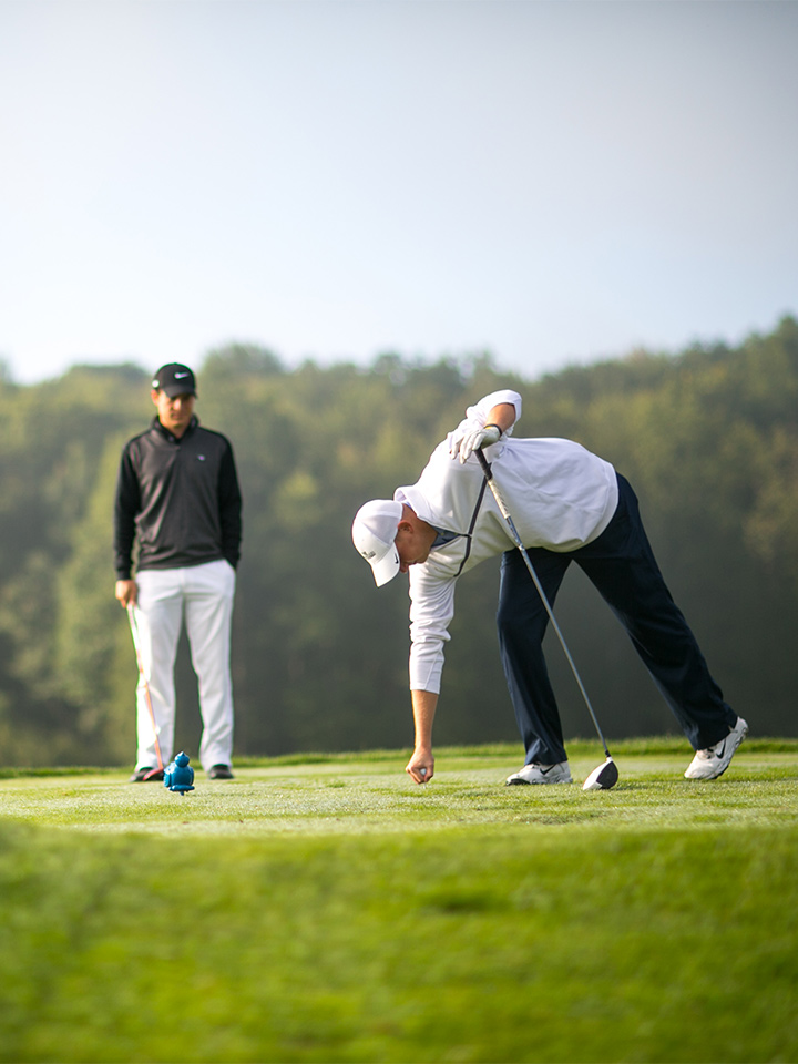 People golfing in the woods