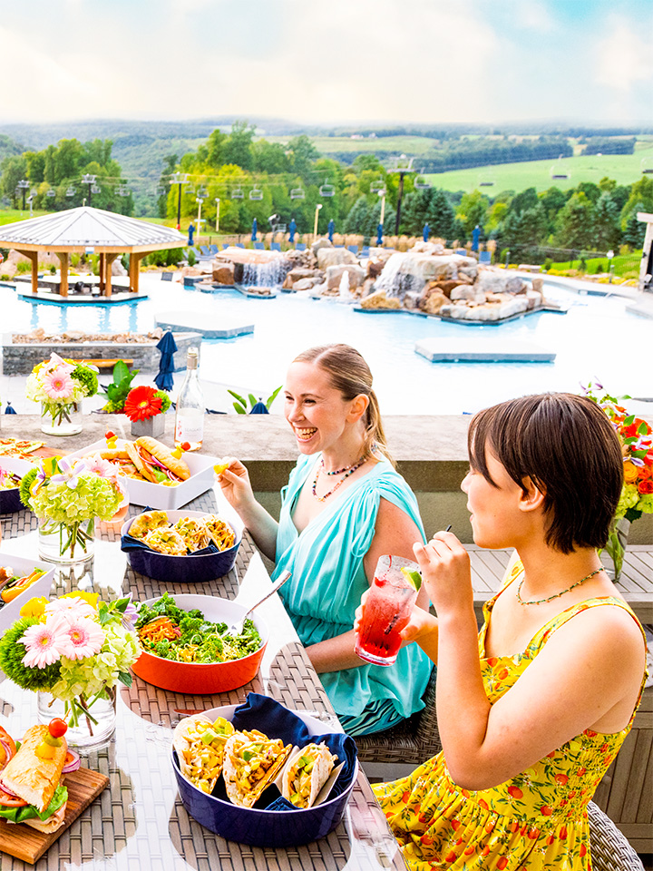 family enjoying dinner on pool deck
