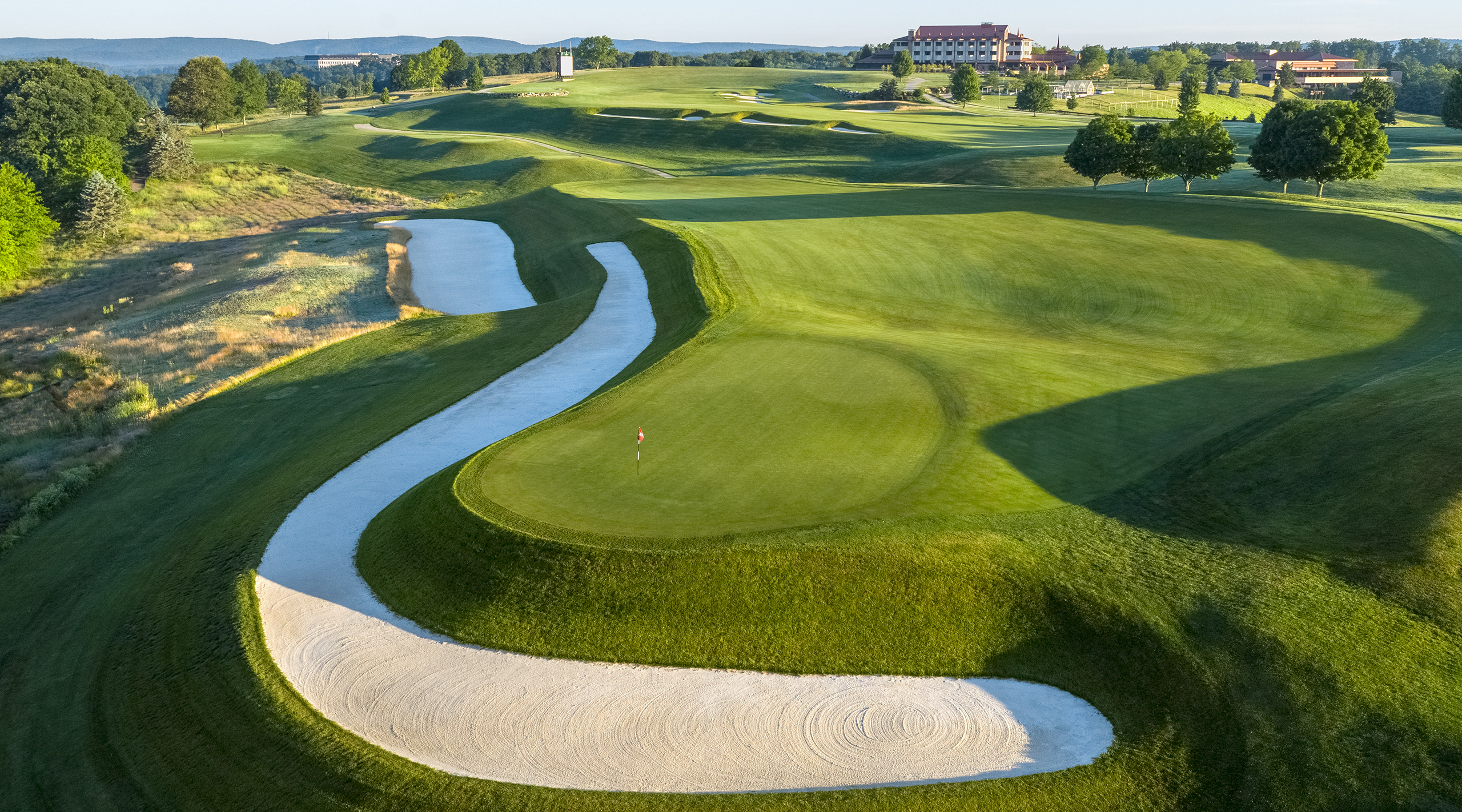 View of Falling Rock boutique hotel at Nemacolin from the green of Mystic Rock's hole #1 and showing the 18th hole in the background.