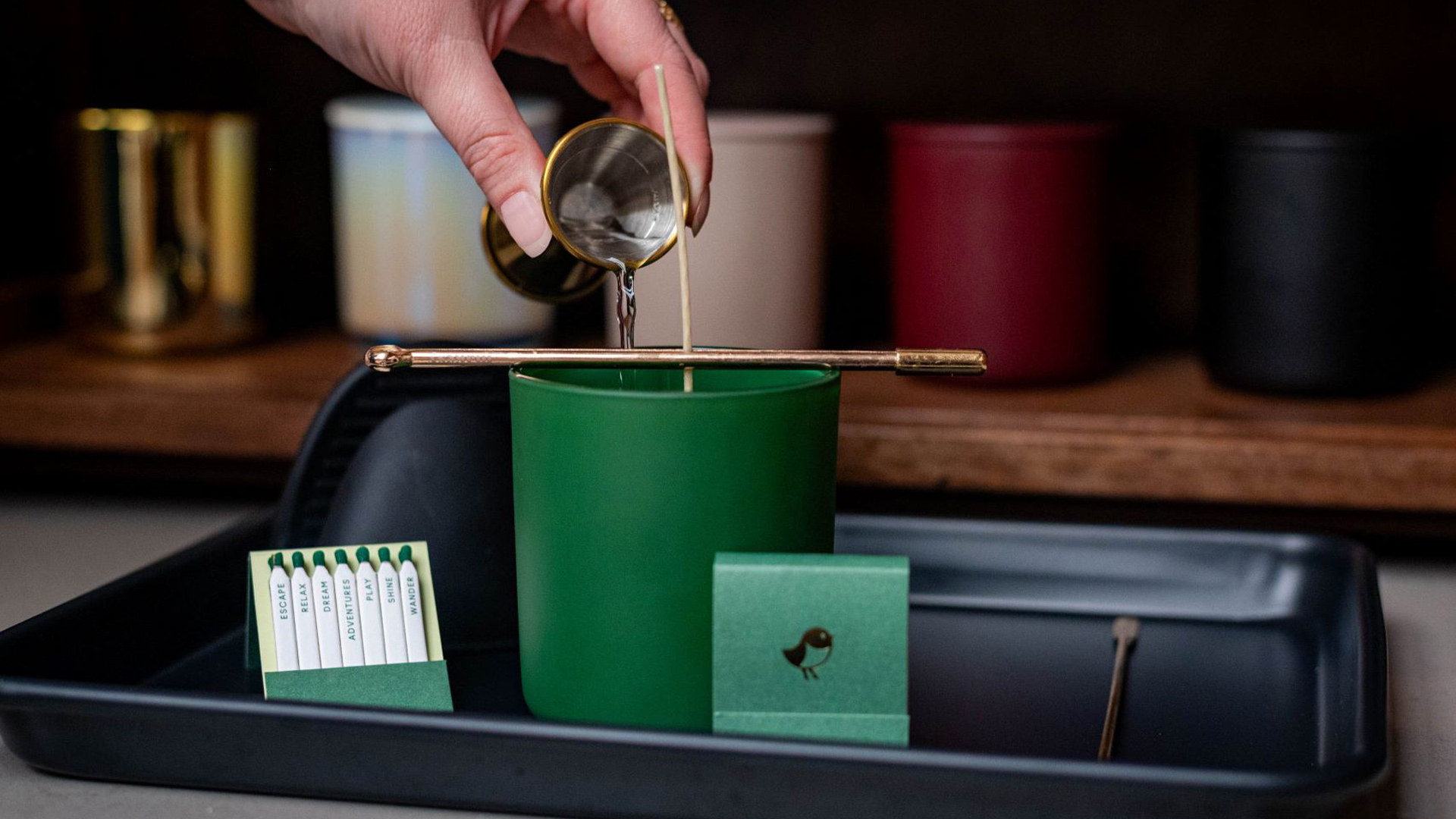 hand pouring wax into candle vessel for a candlemaking class at Nemacolin resort