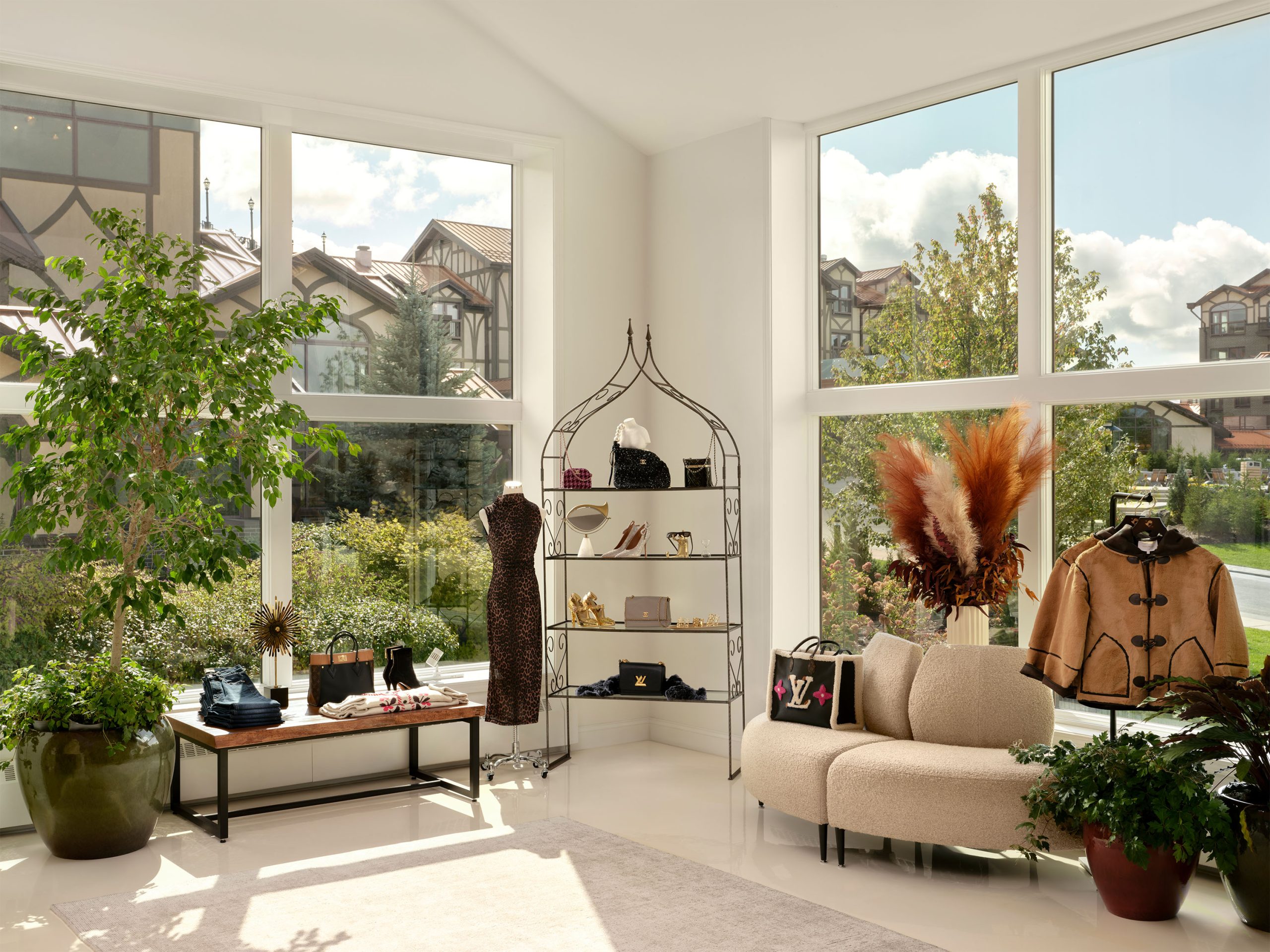 An open shopping space in an indoor mall, with large windows and retail items